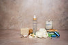 Ritual bundle products including a room spray, candle, inhaler and soap on a textured surface with a neutral background